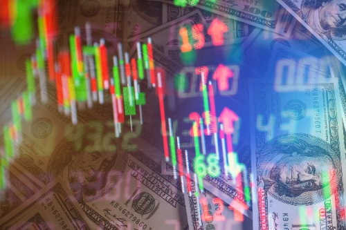 Una composición visual superpuesta que muestra gráficos bursátiles digitales de velas verdes y rojas sobre un fondo denso de billetes de cien dólares estadounidenses.